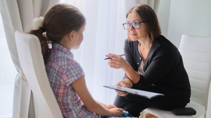Woman social worker talking to girl. Child psychology, mental health
